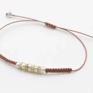 Tendencia Pulsera hilo macrame 0,65mm metalico oro rosa con perlas naturales,ruedas estriadas oro mate y nudos macramé. Es regulable.