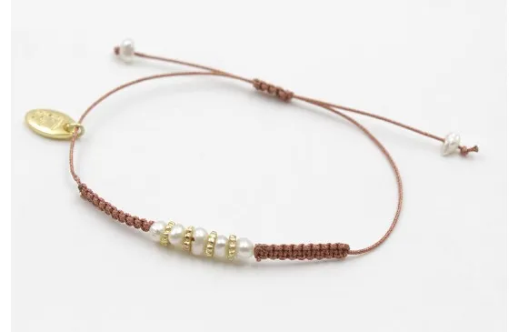 Tendencia Pulsera hilo macrame 0,65mm metalico oro rosa con perlas naturales,ruedas estriadas oro mate y nudos macramé. Es regulable.